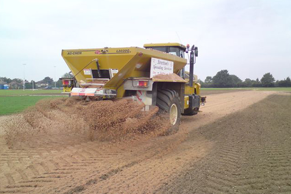 An image of us spreading lime on a field